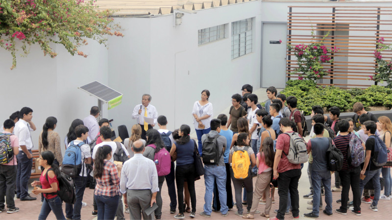Dr. Alejandro Ancajima explicando a los alumnos y profesores la importancia del cargador solar.
